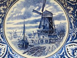 Beautiful Delftware plate featuring a windmill and village scene in traditional blue and white.