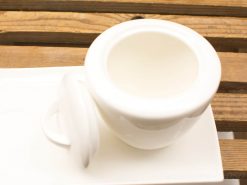 Elegant white ceramic dish with lid, perfect for serving or storage in any kitchen.