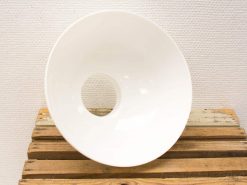 Elegant white ceramic bowl on rustic wooden plank, blending modern design with natural elements.