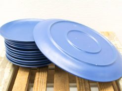 Stylish blue plates stacked for casual dining and outdoor gatherings on a rustic surface.