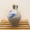 Elegant ceramic jug with blue stripes, cork stopper, perfect for serving beverages.