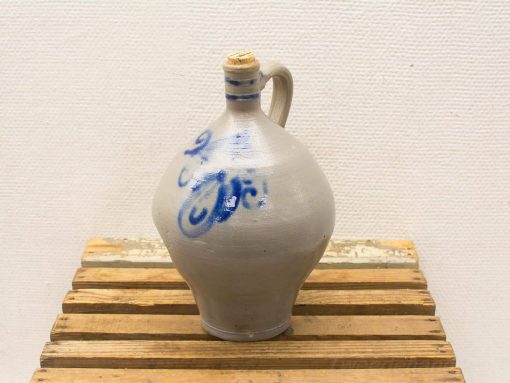 Elegant ceramic jug with blue stripes, cork stopper, perfect for serving beverages.