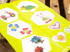 Vibrant bead designs craft sheet for kids featuring playful characters and floral motifs.