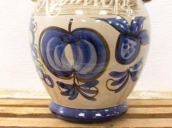 Colorful vintage ceramic vase with blue fruits and playful green leaves, perfect for decor.