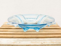 Elegant blue glass dish on wooden surface, perfect for presenting fruits and snacks.