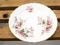 Elegant floral porcelain plate with gold accents, featuring pink roses and green leaves.