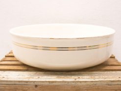 Elegant white bowl with gold and charcoal stripes on a rustic wooden base.