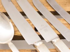 Elegant vintage stainless steel cutlery set, featuring polished knives and a large serving spoon.