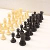 Classic cream and black chess set showcasing elegant, detailed pieces for strategic gameplay.