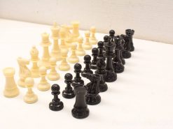 Classic cream and black chess set showcasing elegant, detailed pieces for strategic gameplay.