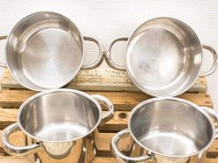 Stylish stainless steel cookware set on a rustic wooden surface, perfect for any kitchen.