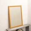 Stylish mirror with light wooden frame, perfect for enhancing modern interiors.