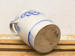 Vintage ceramic jug with blue patterns, rustic charm, perfect for home decor or collections.