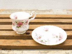 Elegant porcelain teacup and saucer set with pink rose design and gold accents.