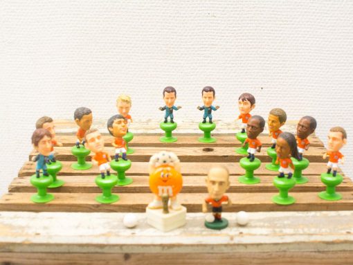 Vintage tabletop football set featuring colorful figurines and a playful mascot for nostalgic fun.