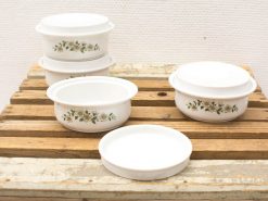 Vintage white ceramic bowls with floral designs, perfect for serving and baking.