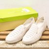 Stylish white perforated shoes in a green box, perfect for casual outings and warm weather.