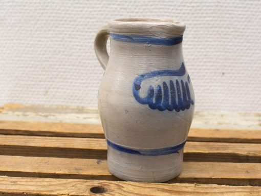 Handmade clay jug with blue design, combining rustic charm and functional elegance.