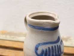 Rustic ceramic jug with blue patterns, perfect blend of art and functionality.