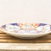 Vibrant ceramic plate with intricate traditional designs, perfect for decoration or serving food.