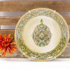 Elegant vintage plate with ornate egg design and vibrant floral accents on rustic wood.