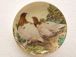 Vibrant birds adorn an elegant decorative plate, showcasing exquisite artistry and natural beauty.