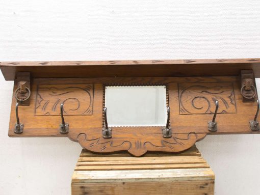 Vintage wooden wall rack with mirror and hooks for stylish entryway or living room decor.