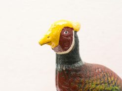 Colorful pheasant sculpture enhances vintage decor with artistic flair and nature-inspired design.