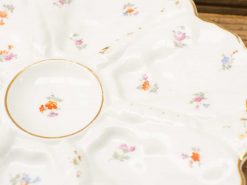 Elegant vintage porcelain plate with floral design and gold accents, perfect for serving or display.