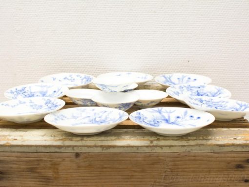 Elegant blue and white porcelain plates with traditional Chinese floral designs on a rustic backdrop.