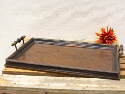 Rustic wooden tray with metal handles and vibrant flower, perfect for serving and décor.