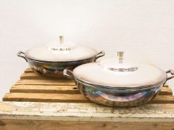 Elegant stainless steel cooking pots on a rustic wooden surface, blending style and functionality.