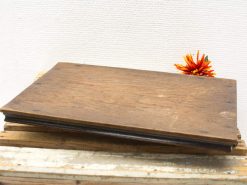 Rustic wooden board with vibrant orange flower, perfect for vintage decor enthusiasts.