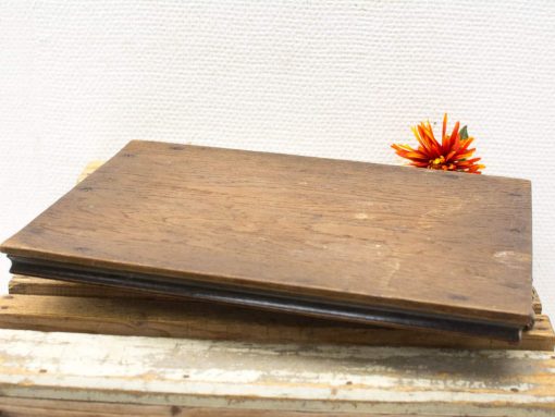 Rustic wooden board with vibrant orange flower, perfect for vintage decor enthusiasts.