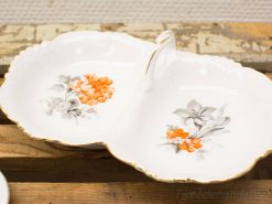 Elegant vintage porcelain serving dish with floral design and central handle, perfect for any occasion.