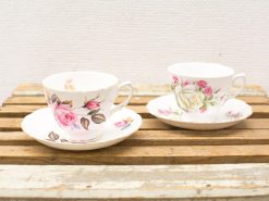 Elegant vintage floral teacups on a rustic wooden surface, perfect for afternoon tea.