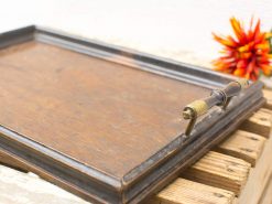 Elegant vintage wooden tray with brass handle, perfect for serving or decor.