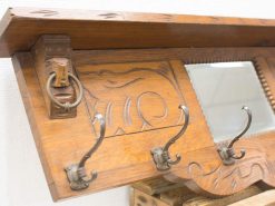 Rustic wooden shelf with mirror and antique hooks, perfect for stylish storage solutions.