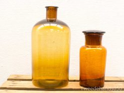 Vintage amber glass bottles on rustic wooden surface, perfect for decoration and collectors.