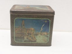 Antique tin box featuring a charming coastal scene, perfect for storage or decor.