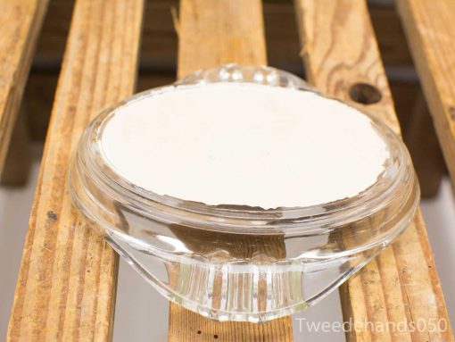 Elegant glass dish with glossy white interior on rustic wood surface, perfect for food presentation.