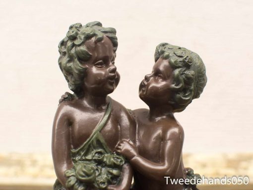 Charming bronze statue of two playful children embodying friendship and youthful innocence.