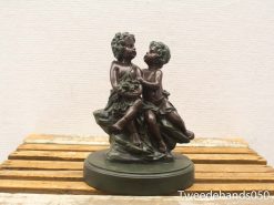 Bronze sculpture of joyful children celebrating innocence and friendship in playful interaction.