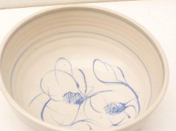 Handmade off-white ceramic bowl with elegant blue abstract pattern, ideal for decor or serving.