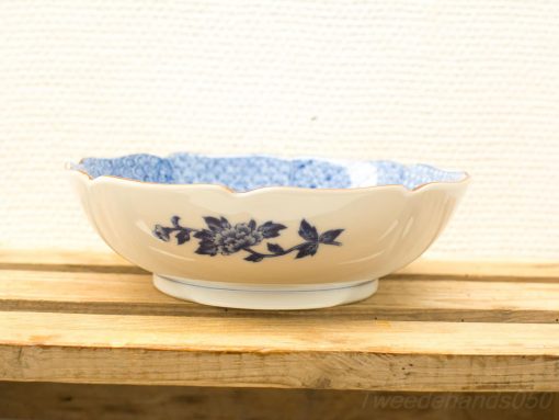 Elegant ceramic bowl with blue floral patterns and scalloped edges, perfect for decor or serving.