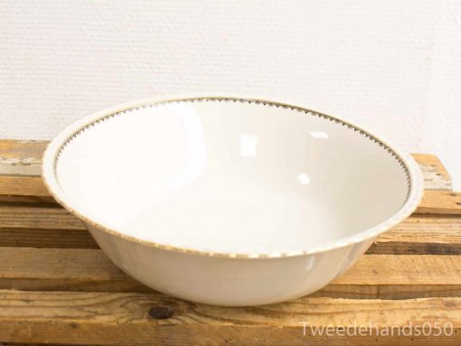 Elegant white ceramic bowl with a golden rim on rustic wooden surface. Perfect decor.