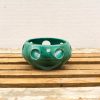 Whimsical turquoise ceramic bowl with playful design, perfect for decor or small items.