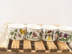 Charming ceramic cups featuring butterfly and floral designs, perfect for nature lovers and home decor.