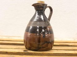 Elegant ceramic jug with cork stopper, showcasing artisanal craftsmanship and earthy tones.