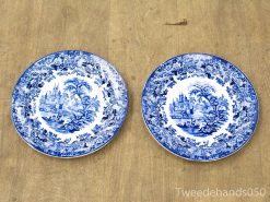 Elegant blue and white ceramic plates featuring serene landscapes and a majestic castle design.